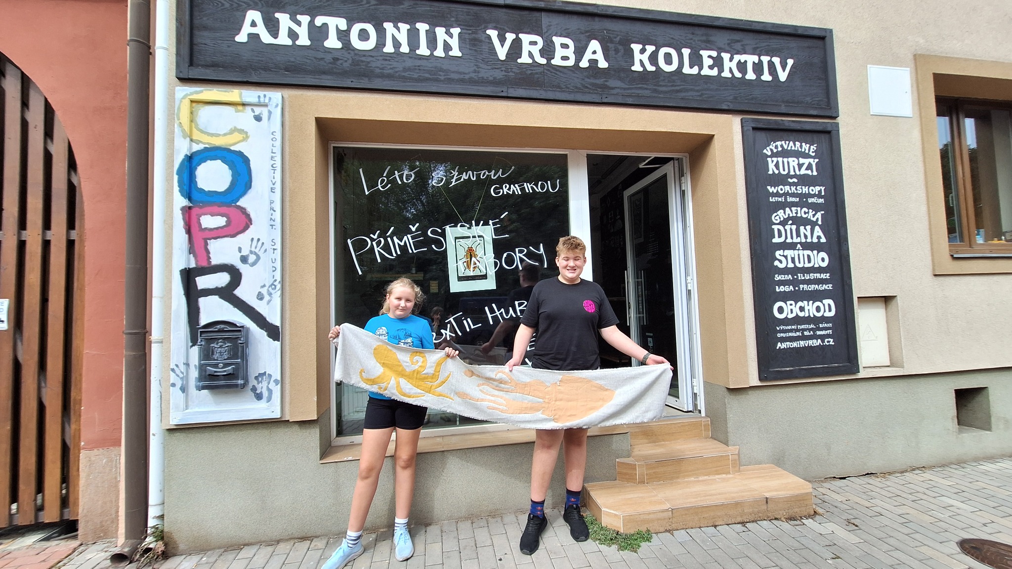Kami a Vojta drží před ateliérem hotový lněný běhoun s mořskými tvory